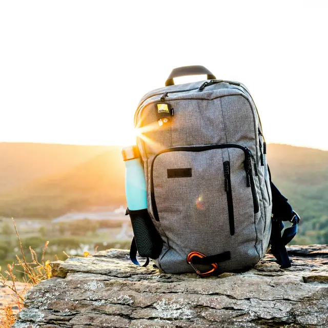 Rucksack auf einem Felsen mit einer Wasserflasche