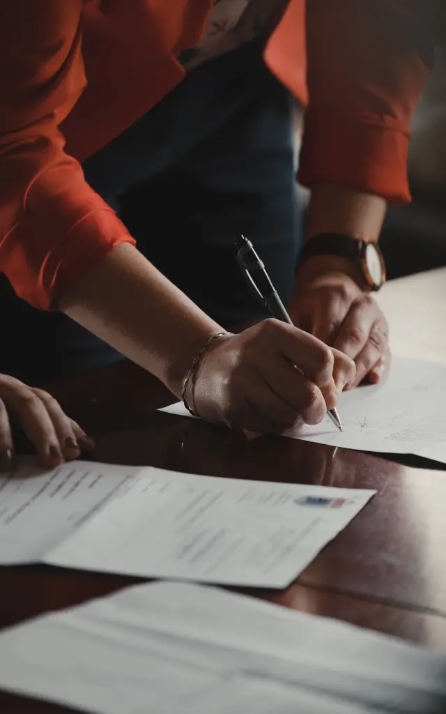 Deux personnes signent des documents sur une table