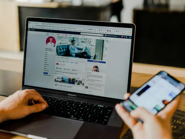Personne utilisant un ordinateur portable et un smartphone pour accéder aux réseaux sociaux