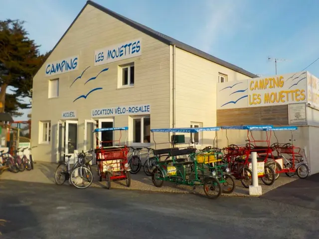 Bâtiment du camping Les Mouettes avec des vélos et des rosalies devant