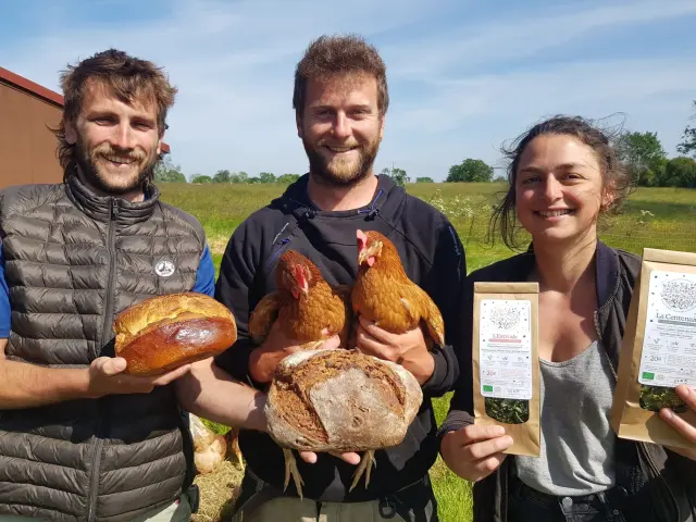 Trois personnes tenant des poules et du pain à la ferme de la mouvette