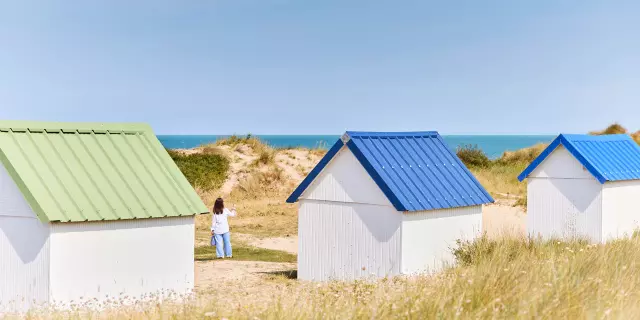 Trois cabines de plage avec des toits de couleurs différentes à Gouville sur Mer