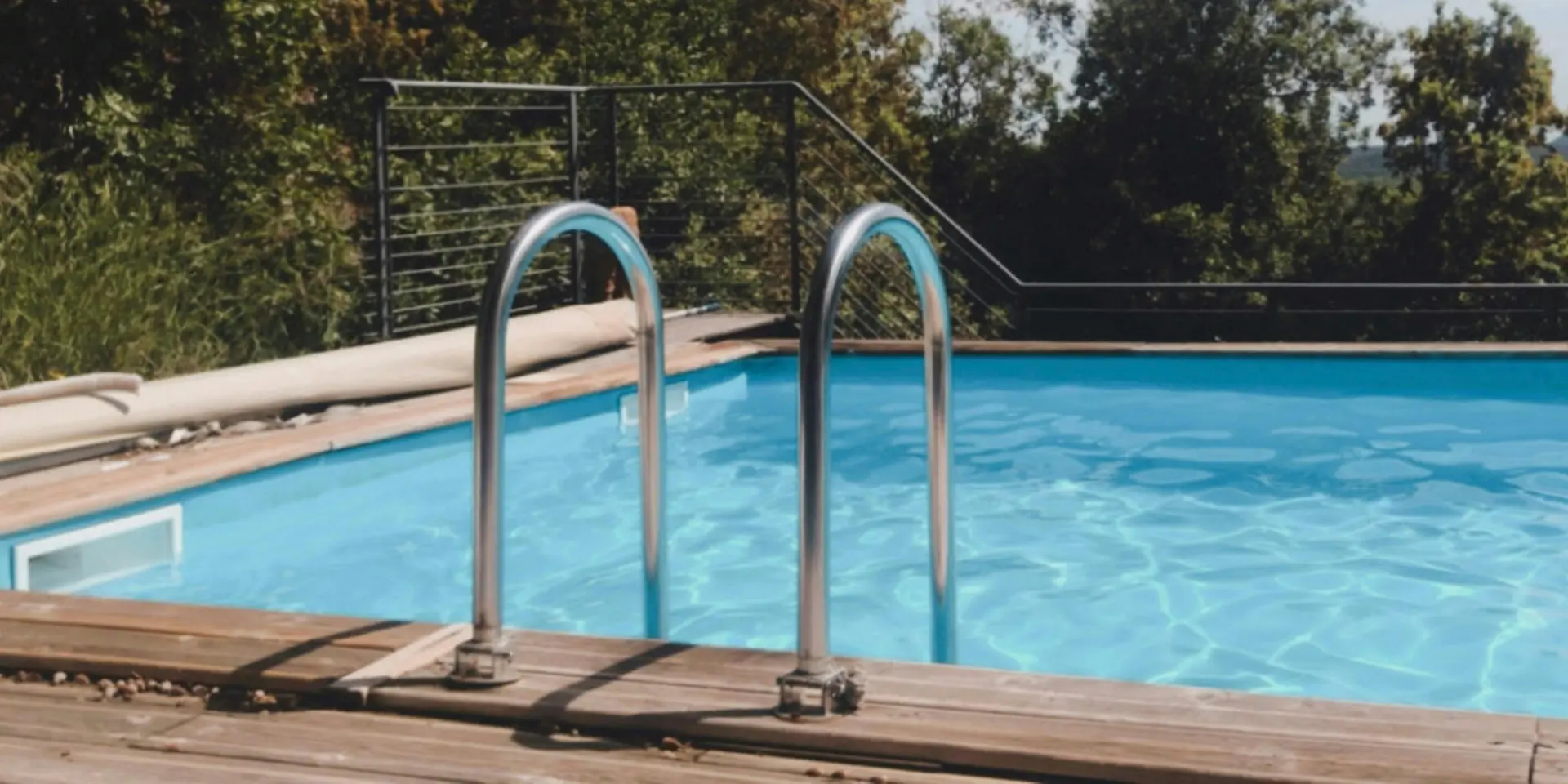Piscine avec des escaliers métalliques et une vue sur des arbres