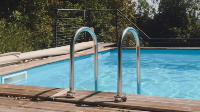 Piscine avec des escaliers métalliques et une vue sur des arbres