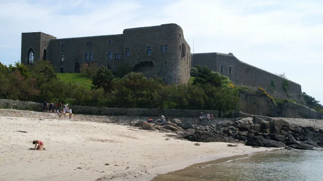 Stone castle on a hill above a sandy beach