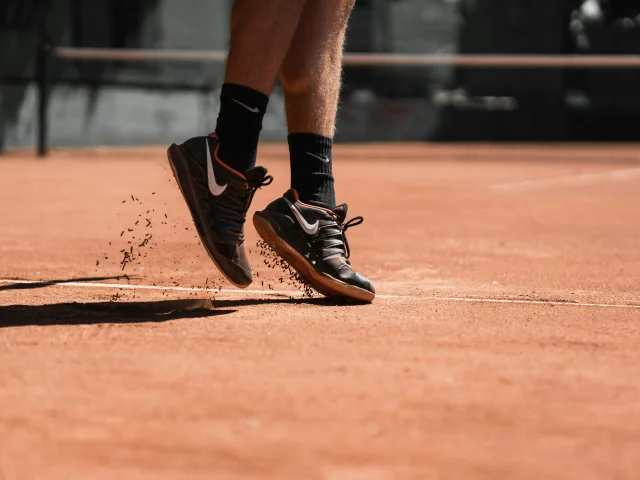 Foot of a tennis player in motion on clay court