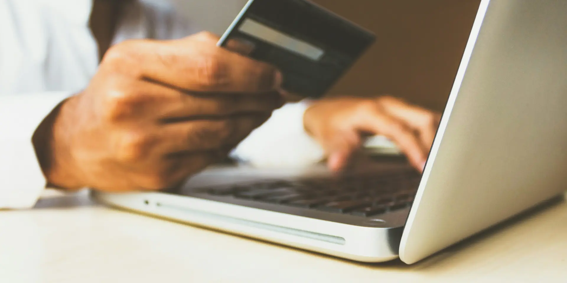 Personne utilisant un ordinateur portable et une carte de crédit