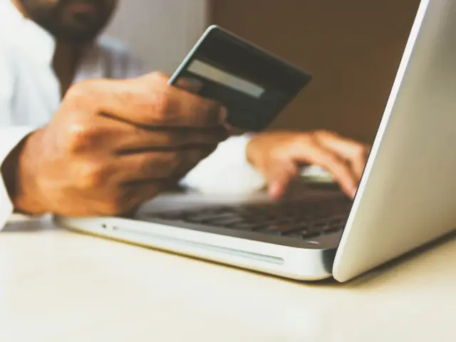 Personne utilisant un ordinateur portable et une carte de crédit