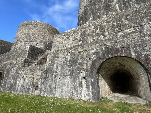 Steinmauer einer mittelalterlichen Festung mit einem Bogen und Türmen