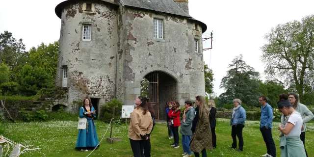 Groupe de personnes écoutant une guide devant le château de Chanteloup