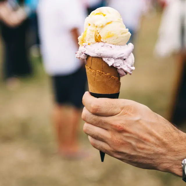 Main tenant une glace à la vanille et au citron dans un cornet