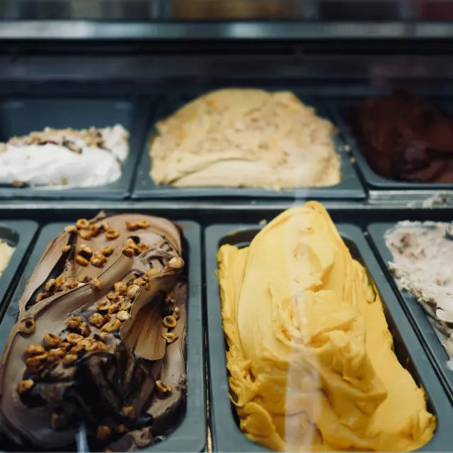 Différentes saveurs de crème glacée dans des bacs en métal