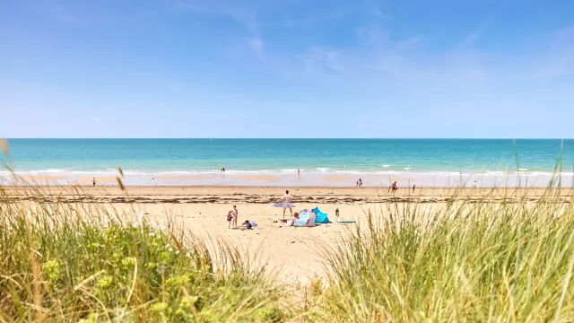 Menschen genießen einen sonnigen Tag an einem Sandstrand