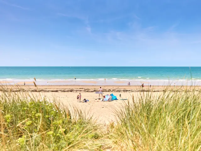 Menschen genießen einen sonnigen Tag an einem Sandstrand