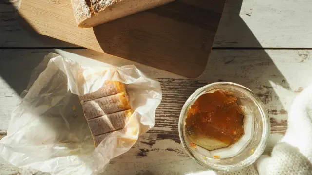 Sticky bun, walnut bread, and jam on a wooden table