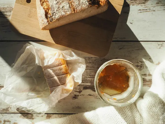 Rosinenbrötchen, Nussbrot und Marmelade auf einem Holztisch