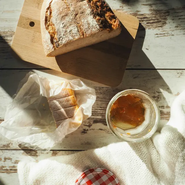 Sticky bun, walnut bread, and jam on a wooden table