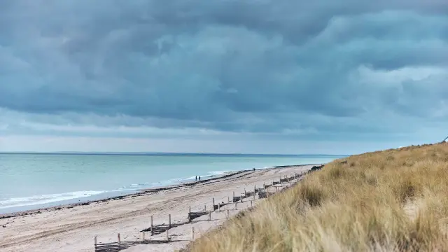 Sandy beach with dark clouds above