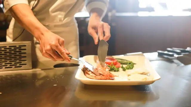 Un chef cuisinier prépare une assiette gourmande avec des ingrédients frais