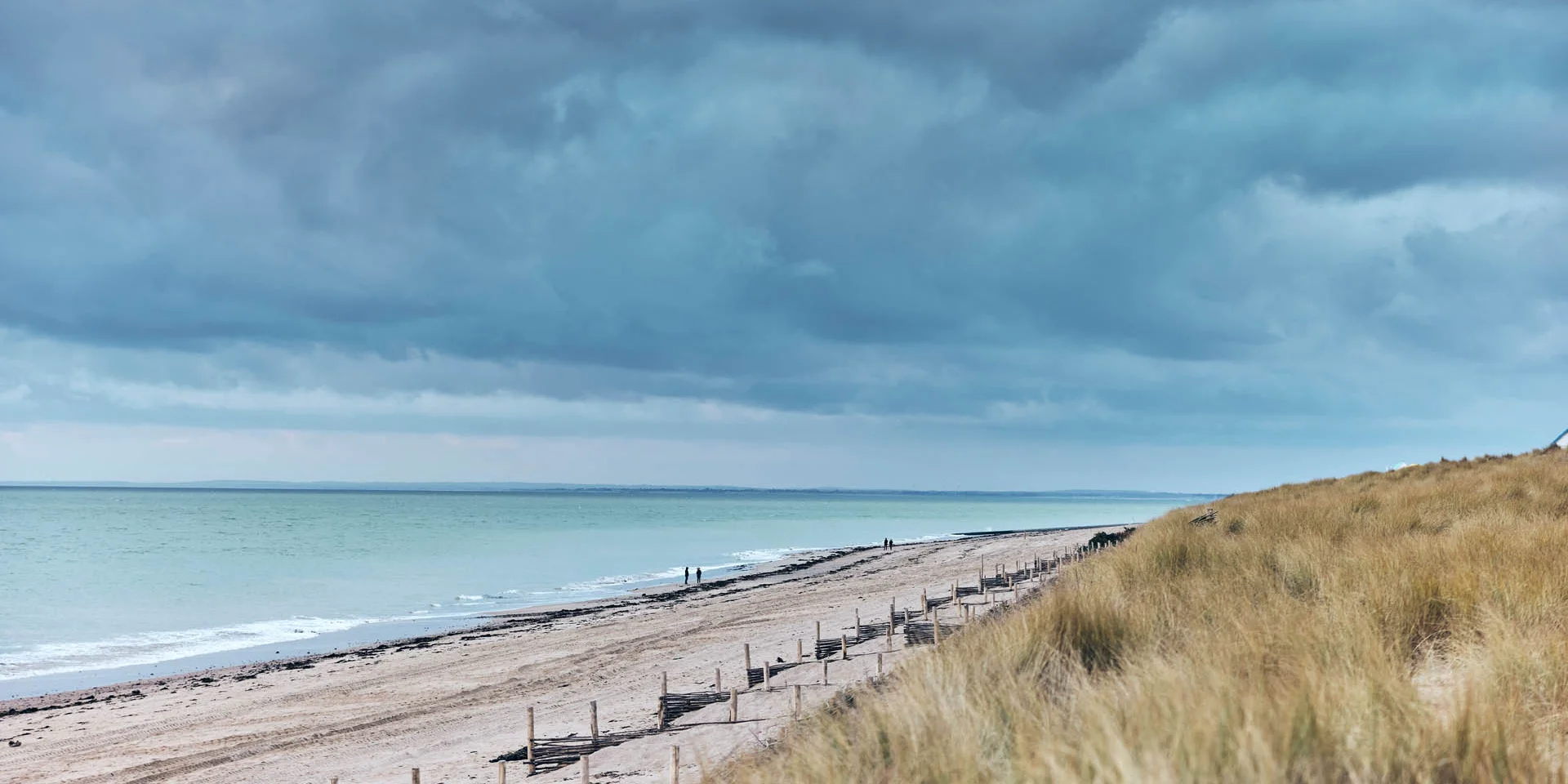 Sandy beach with dark clouds above