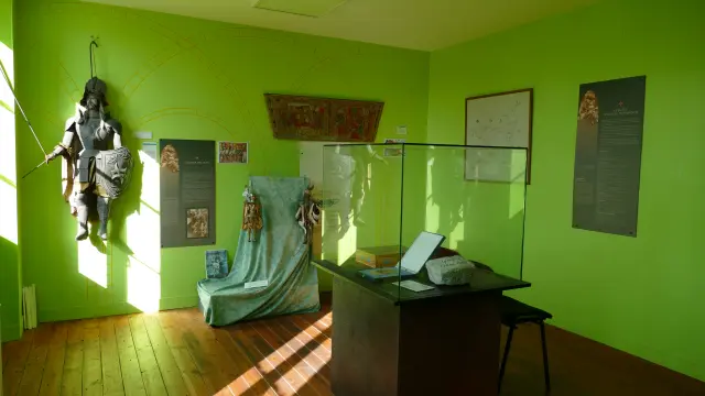 Salle d'exposition avec des artefacts historiques et des panneaux d'information au musée de Hauteville La Guichard
