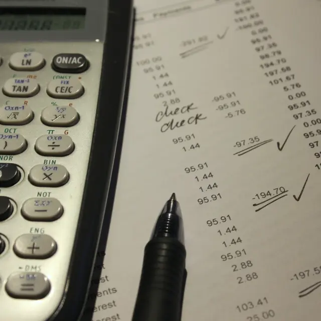 Calculatrice, stylo et document avec des chiffres et des calculs