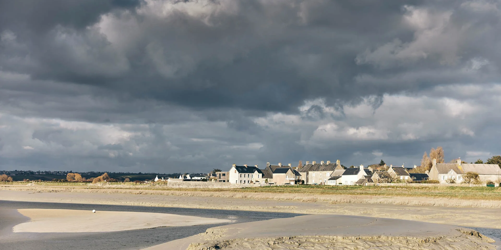 Coastal village with white houses and a cloudy sky