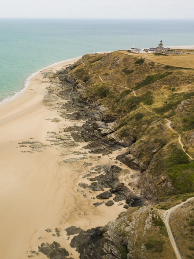 Aerial view of a sandy beach bordered by a cliff and the ocean