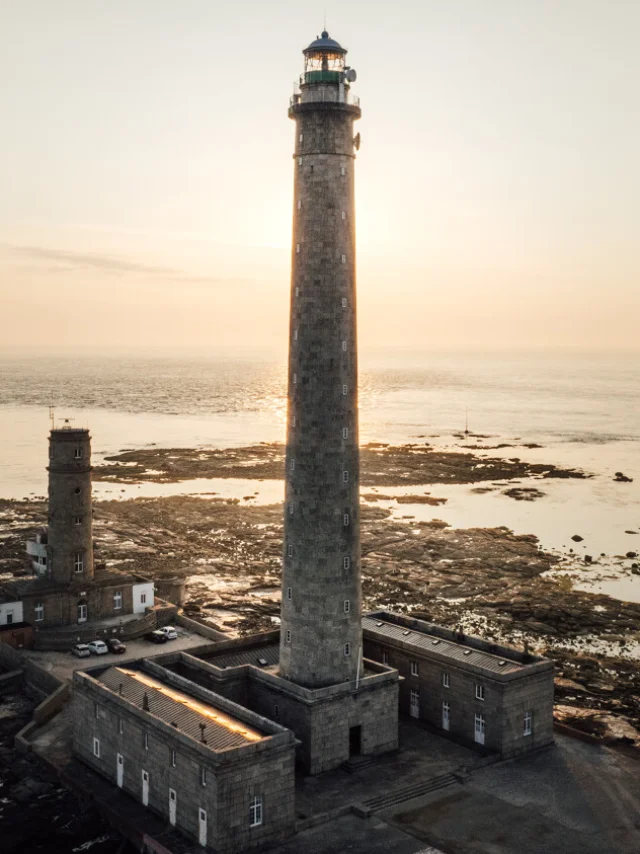 Stone lighthouse with an adjacent building near the ocean