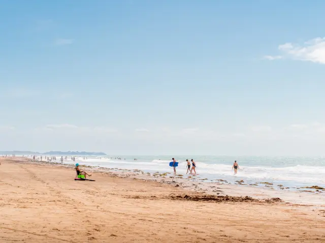 People walking and playing on a sandy beach