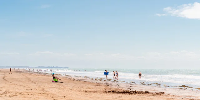 People walking and playing on a sandy beach