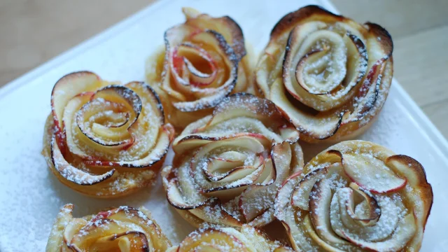 Petits gâteaux en forme de roses avec des tranches de pommes et du sucre glace