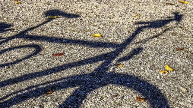 Ombre d'un vélo sur une surface de gravier