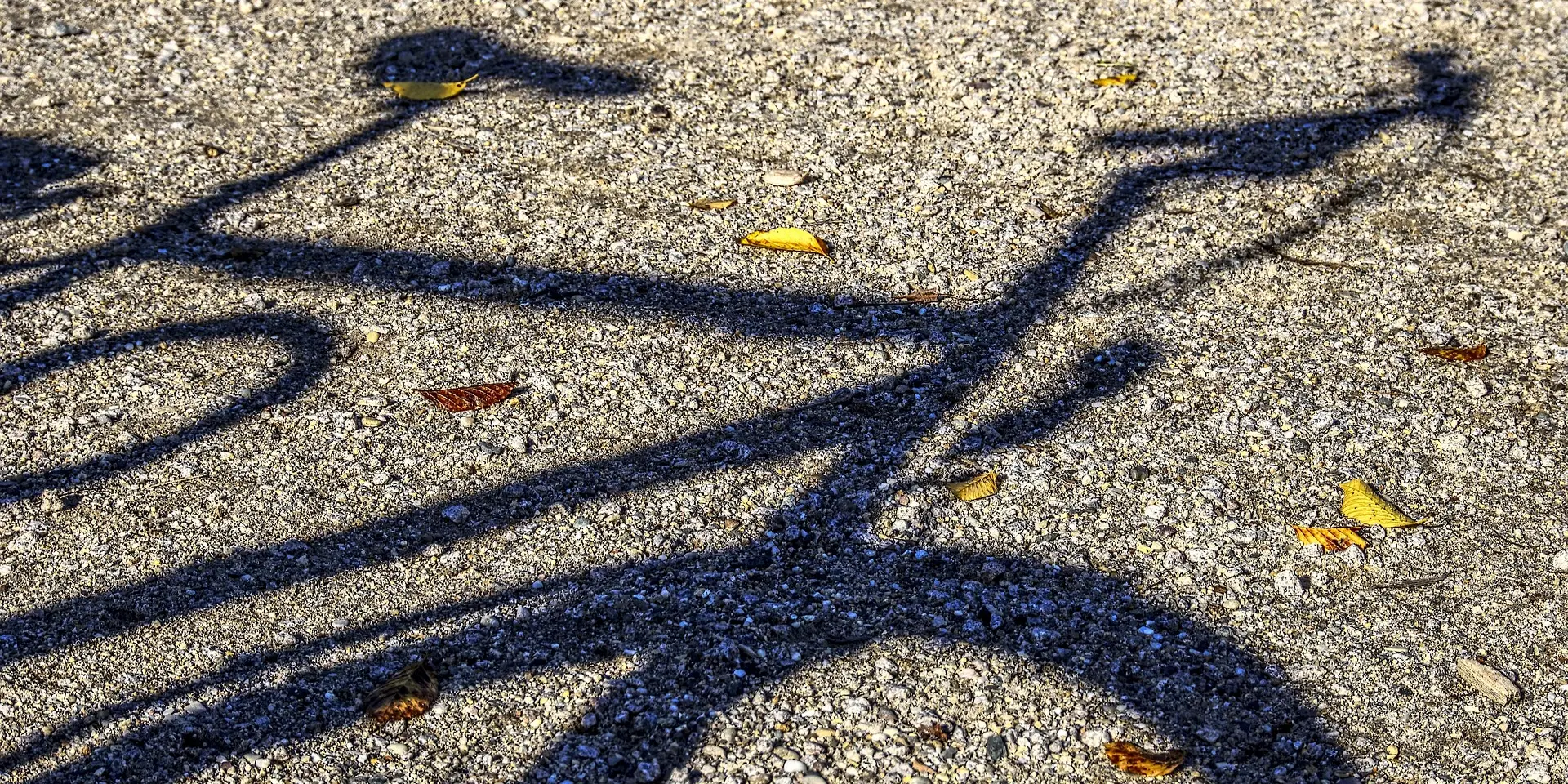 Ombre d'un vélo sur une surface de gravier
