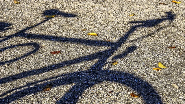 Ombre d'un vélo sur une surface de gravier