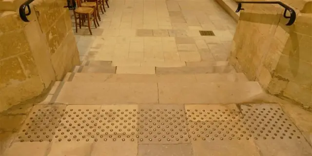 Sol tactile en dalles de pierre avec des pastilles en relief pour les PMR dans la cathédrale de Coutances