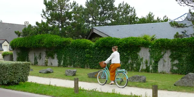 Une personne en orange et blanc fait du vélo sur un espace dédié à Agon-Coutainville