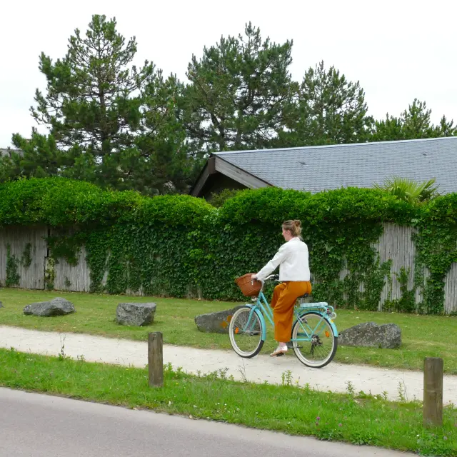 Une personne en orange et blanc fait du vélo sur un espace dédié à Agon-Coutainville